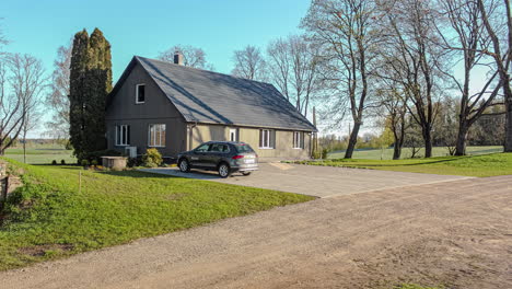 Timelapse-Static-shot-of-country-house-with-car-in-driveway-on-sunny-day-in-fall