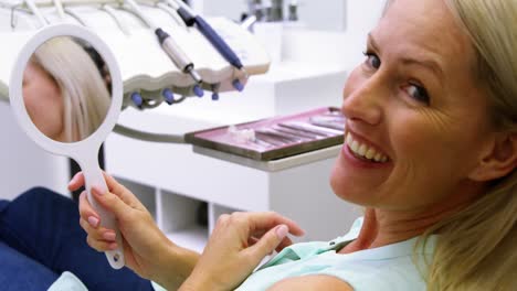 Patient-checking-her-teeth-in-mirror