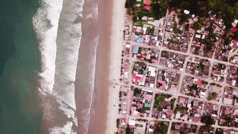 el hermoso complejo turístico de la isla en la playa de olon compuesto por diferentes casas y aguas azules tranquilas - fotografía aérea