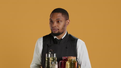 waiter bringing drinks in glasses on a tray for clients at a table,