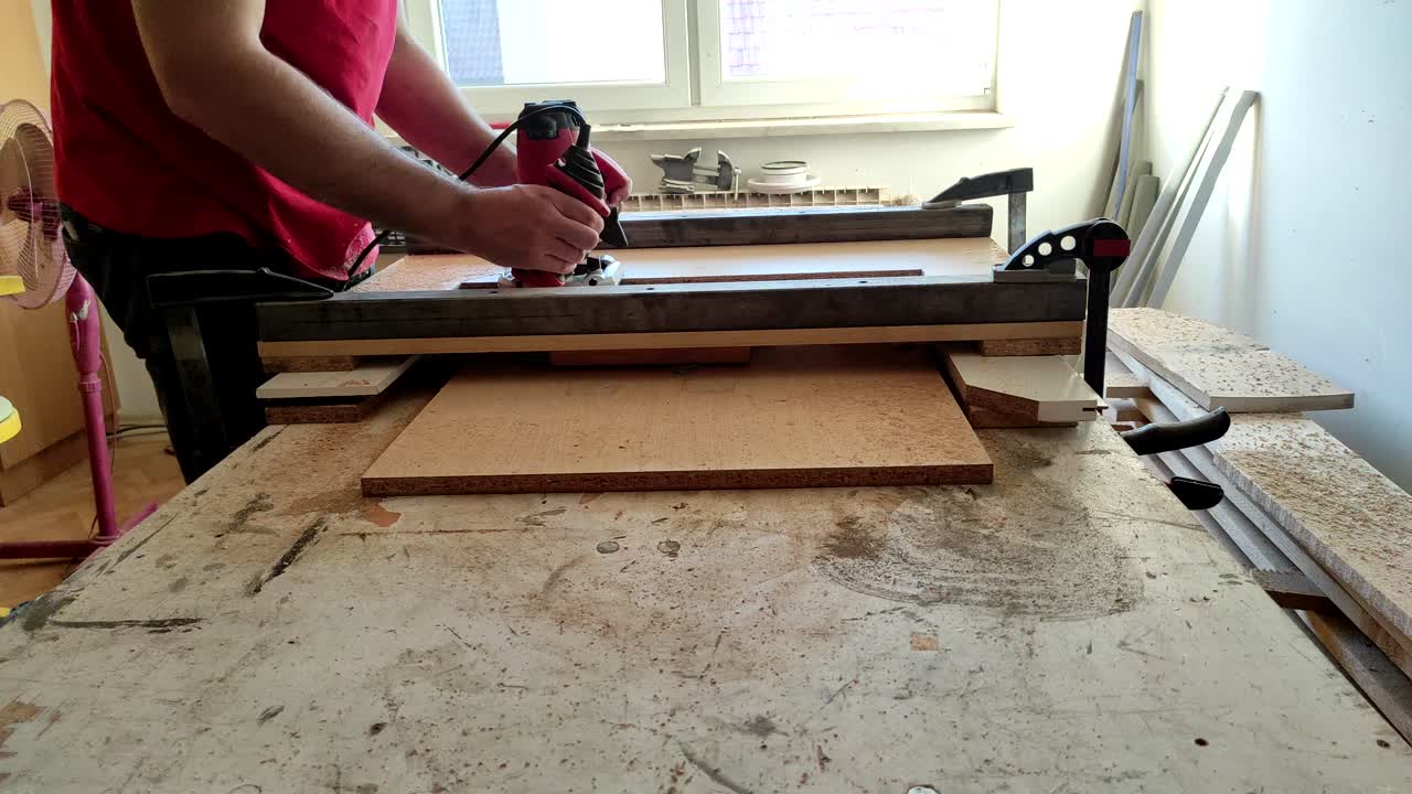 뒤틀린 단단한 나무를 평평하게 하기 위해 밀링 라우터 기계로 작업하는 저속 목공