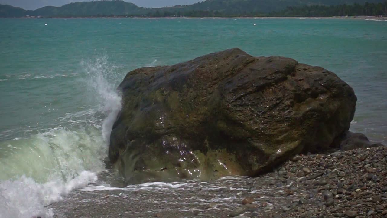 замедленный снимок волн, разбивающихся о скалу вдоль пляжа банбанон, суригао-дель-норте, филиппины