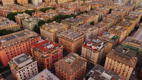 drone descending shot over rooftops of colorful buildings in genoa, italy, at sunset