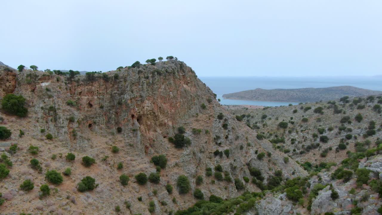 fly over valley between mountains,Crete, Greece. Mediterranean sea in background