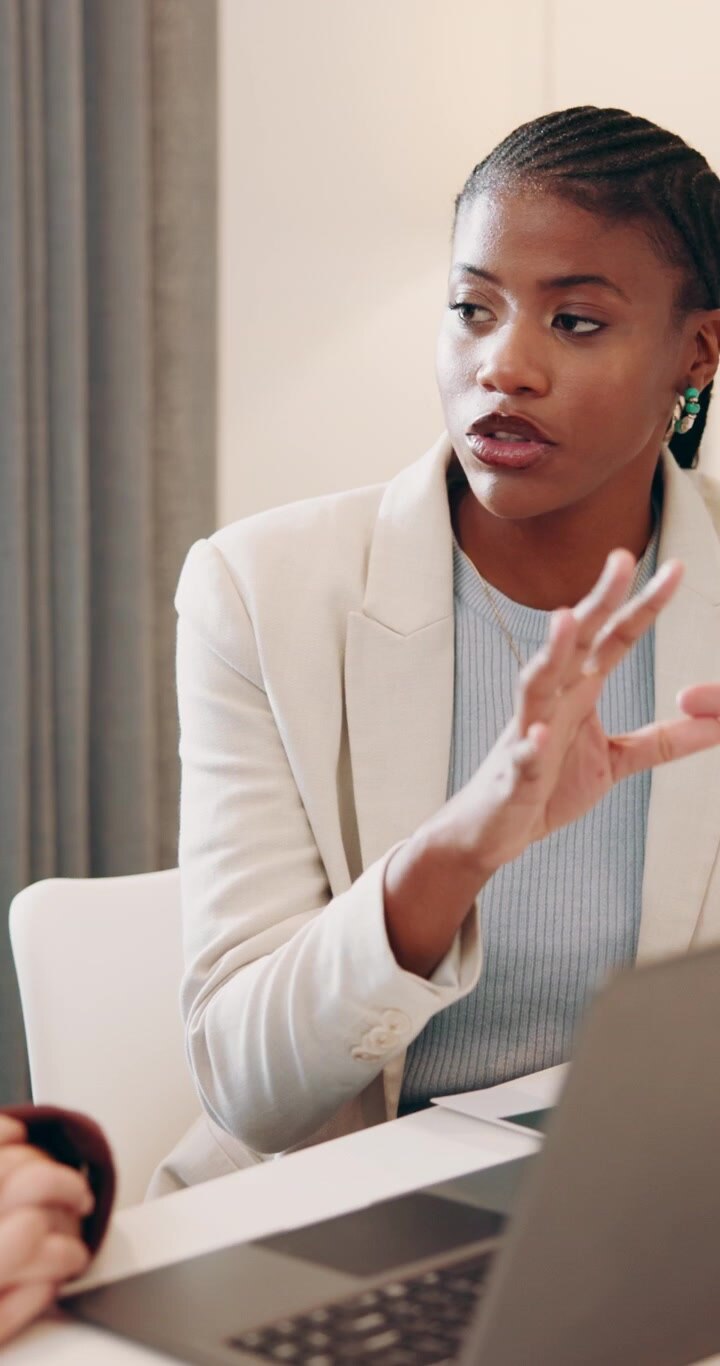Professional Woman Discussing Work During Meeting in Office