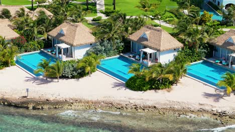 drone telephoto view of hotel villas with private infinity pools looking out on clear caribbean water, curacao