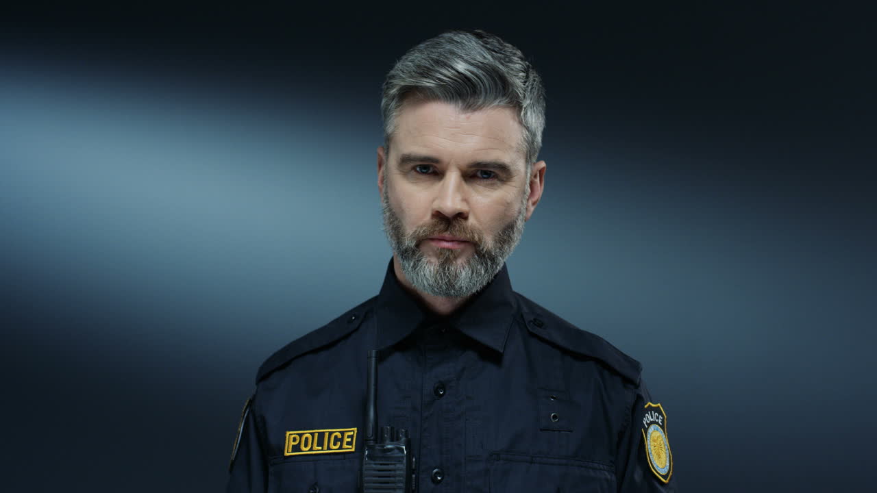 un policía guapo y serio que demuestra su placa y dice palabras sobre los derechos durante el procedimiento de arresto