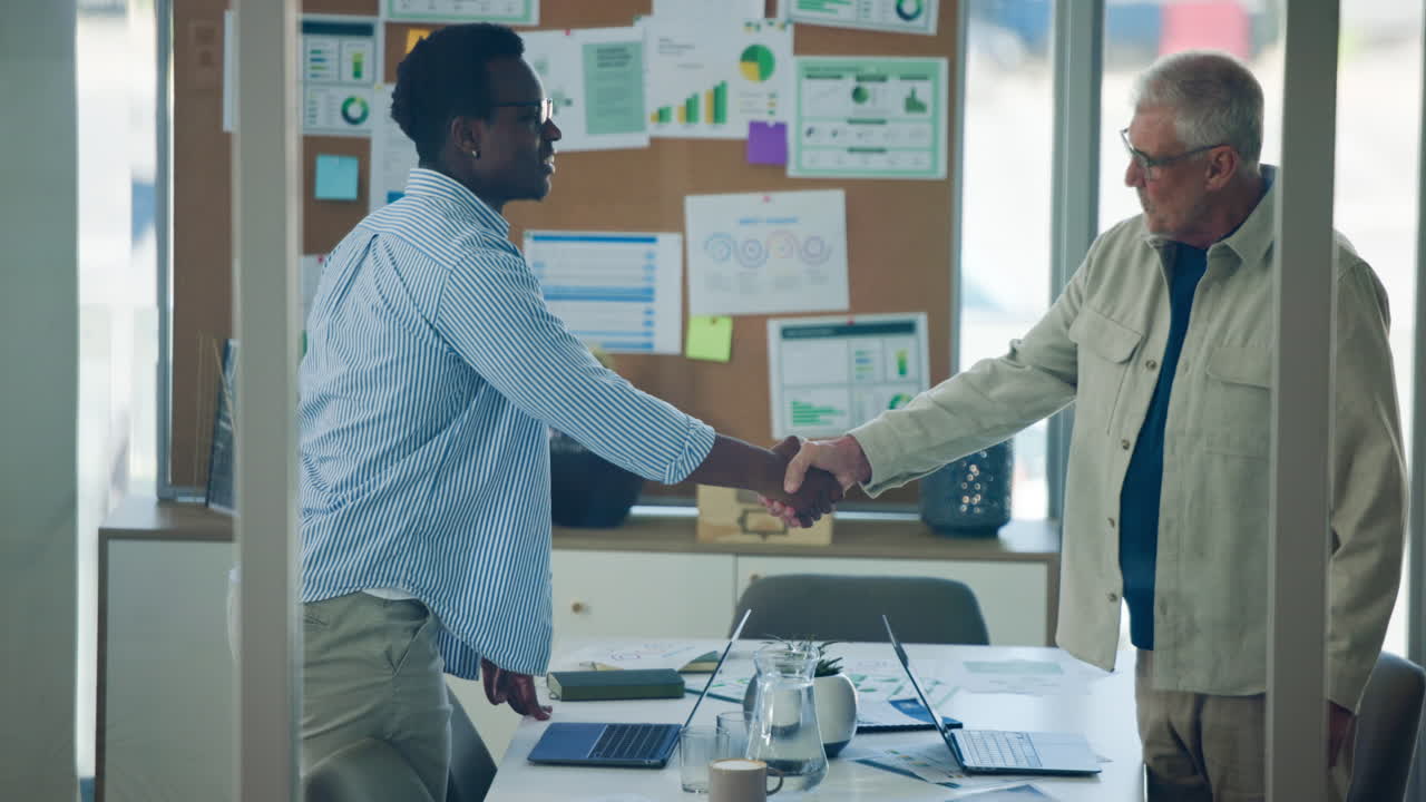 Professional Men Shaking Hands in Modern Office Meeting