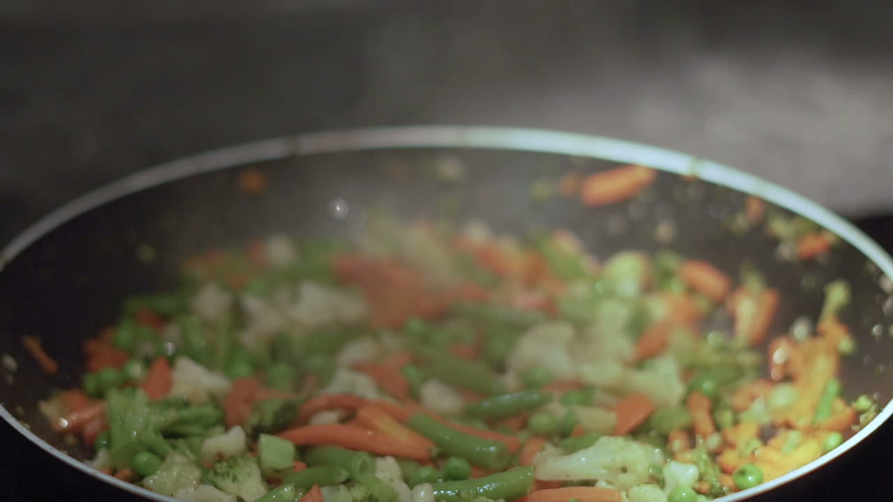 Slow motion cooking vegetables on a pan