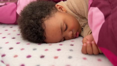two year old afroeuropean child sleeping deeply in his bed