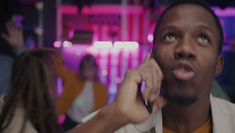 man talking on phone at a party