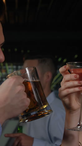 ein paar, das glas bier und cocktail toastet