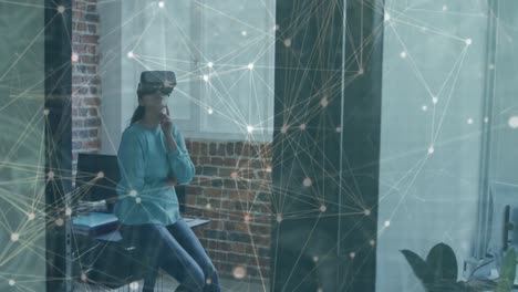 animation of networks of connections over businesswoman with vr headset in office