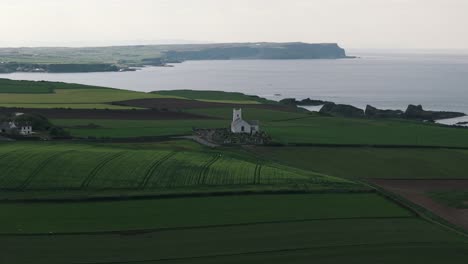 Slow-Descending-Approach-to-Coastal-Church-with-Cliffs-and-Ocean