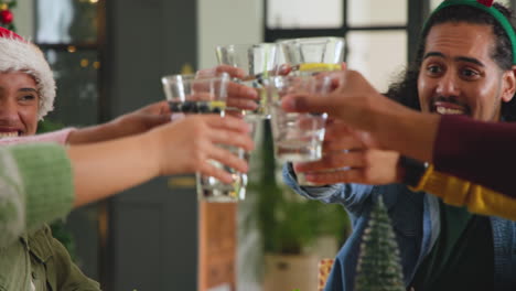 young diverse friends raising glasses in festive cheer at christmas gathering