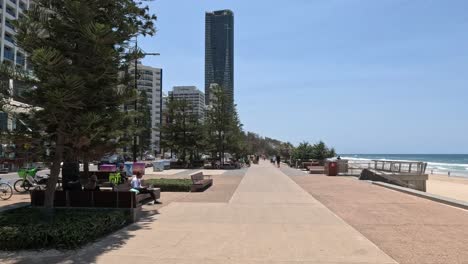 people enjoying a sunny day along a coastal walkway