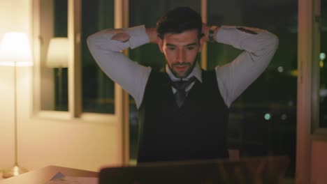 caucasian businessman working on a laptop late night in the office