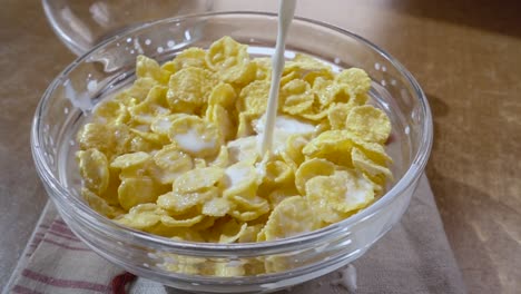 Crispy-yellow-corn-flakes-into-the-bowl-for-the-morning-a-delicious-Breakfast-with-milk.-Slow-motion-with-rotation-tracking-shot.