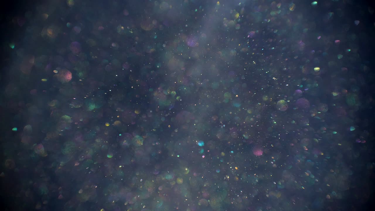 Nature dust raising up slowly on the gray background, blurred bokeh bubbles are glittering falling down on the forefront.