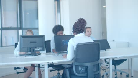 diverse gruppe von händlern in headsets, die im büro arbeiten