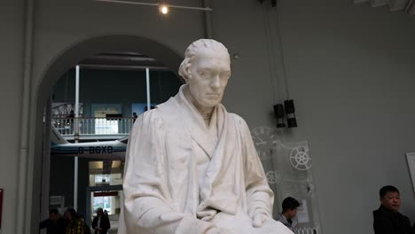 visitors observe james watt statue in edinburgh museum