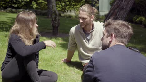 young people sitting on grass and talking