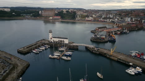 estableciendo un drone disparado sobre el puerto de scarborough y alrededor del faro al amanecer