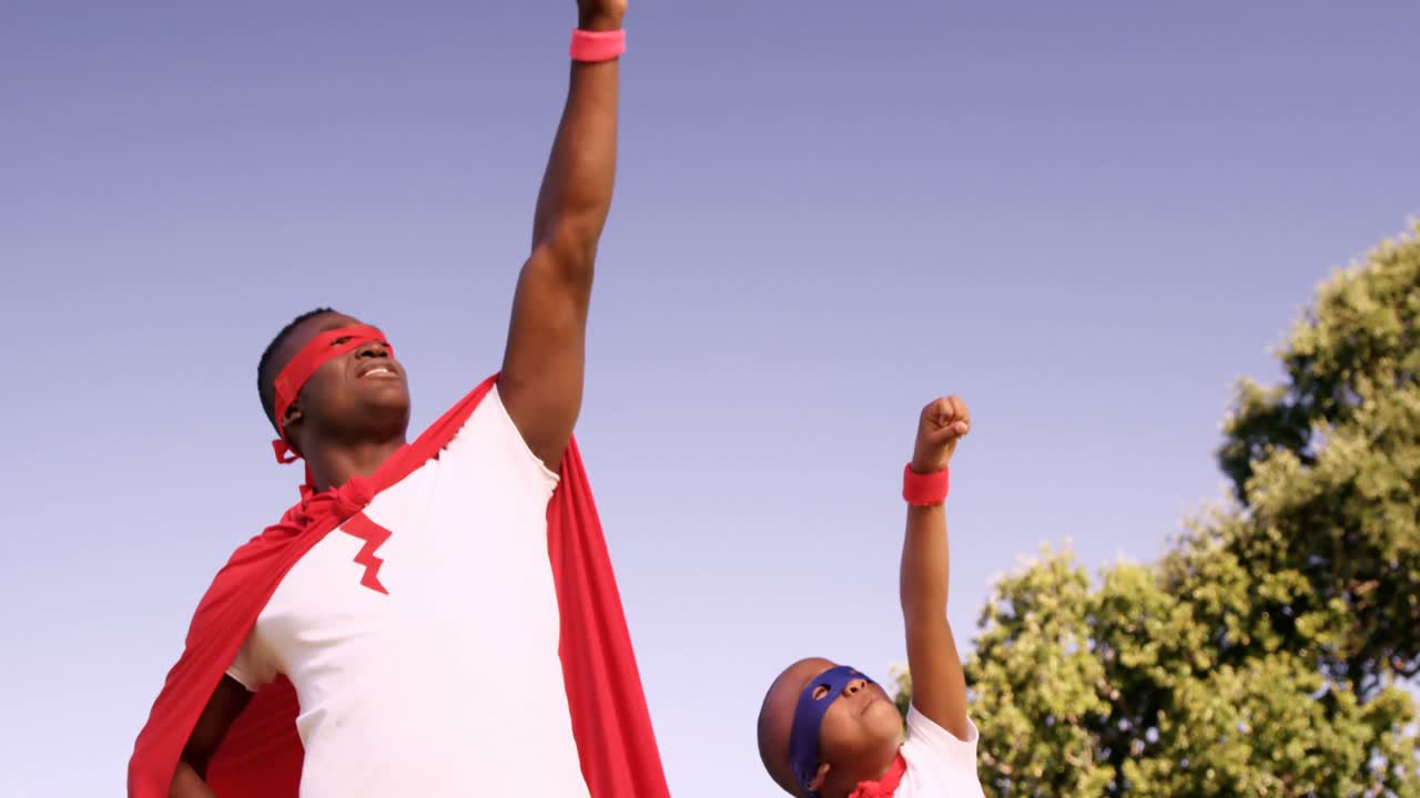 Man playing with his son in costume of superheroes