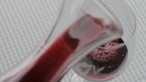 llenar un vaso de vino tinto con un decantador de vidrio, una jarra, un mantel a cuadros