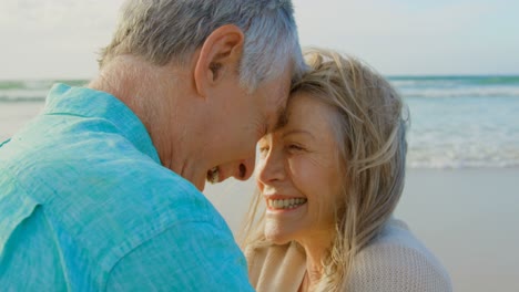 vista lateral de una pareja caucásica senior activa abrazándose en la playa 4k