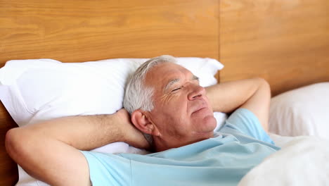 senior man lying in bed sleeping