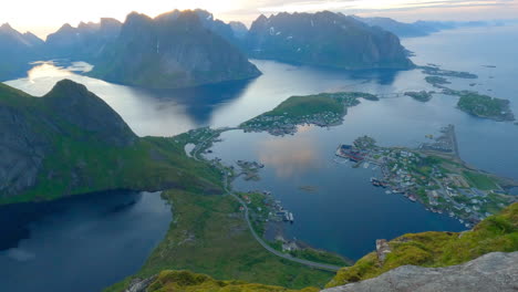 male traveler photographer taking photos from the famous peak reinebringen in lofoten