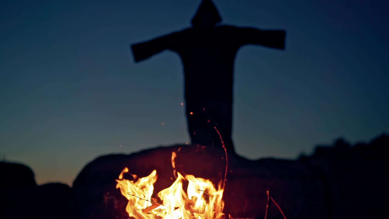 Evil witch conjures in the wizarding lair. Scary Halloween concept. Burning fire.