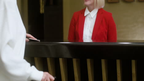 woman completing her check-in at the hotel reception