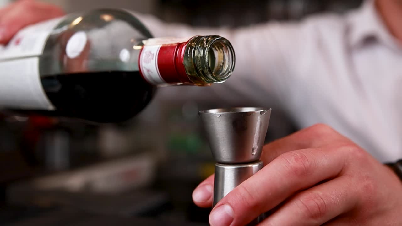 Bartender pouring liquor into a jigger