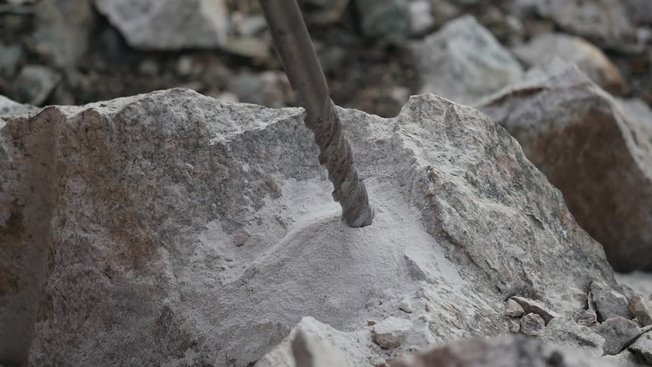 Close up of a driller lifting up from a hole in a rock in slow motion finished
