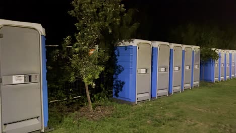 row of portable toilets illuminated at night