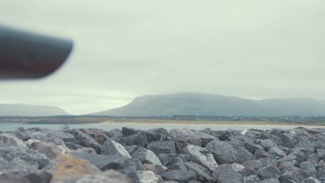 Elderly-man-looks-through-binoculars-sight-seeing-pan-to-reveal-landscape