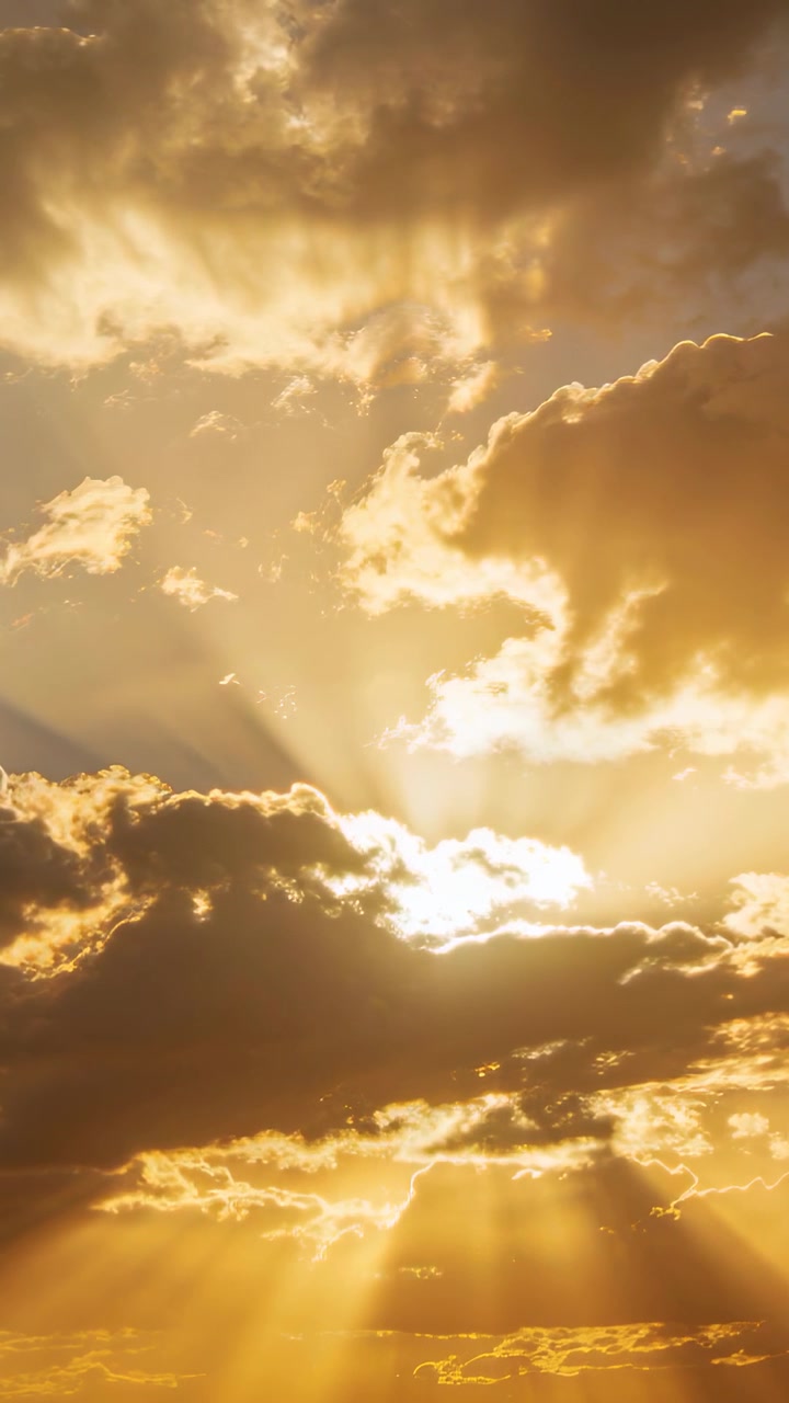 Vertical video: Shifting lower clouds revealing sunbeams over horizon with high streaks for sunrise