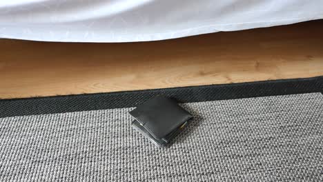 wallet on the floor near a bed