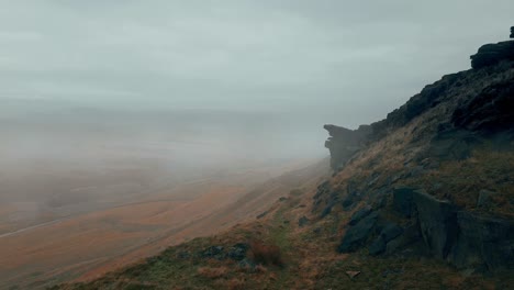 A-thick-fog-covers-the-Pennine-hills,-on-a-foggy-morning,-golden-hills-and-beautiful-rocky-cliffs-and-moorlands