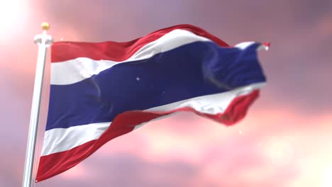 la bandera de tailandia ondeando en el viento al atardecer en un bucle lento