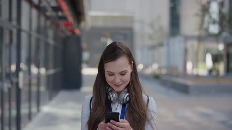 retrato de una joven mujer de negocios hermosa que usa un teléfono inteligente en la ciudad disfrutando de navegar por mensajes en línea enviando mensajes de texto en el móvil sonriendo satisfacción al aire libre urbano cámara lenta