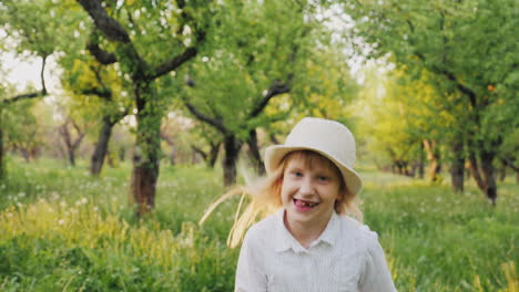 Despreocupada-Chica-Rubia-Con-Un-Sombrero-Corre-Por-El-Huerto-De-Manzanas-Despreocupado-Concepto-De-Infancia-Cámara-Lenta