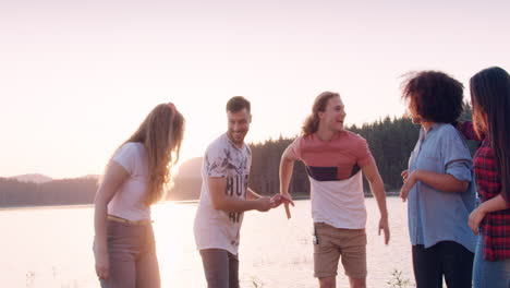 friends enjoying sunset by the lake