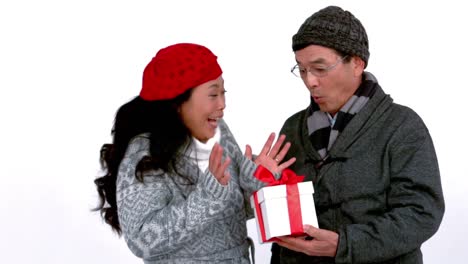 couple in warm clothing holding gift