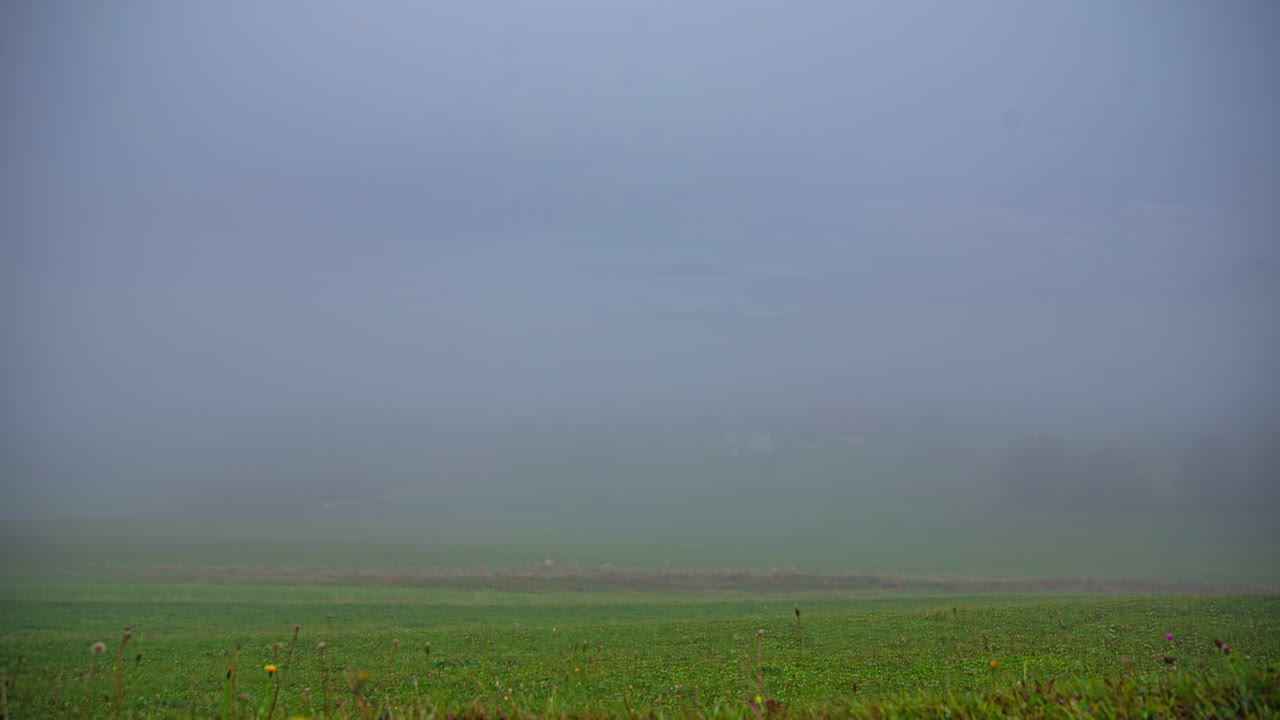 Fog dissipates as the morning sun shines in Austria's countryside - time lapse