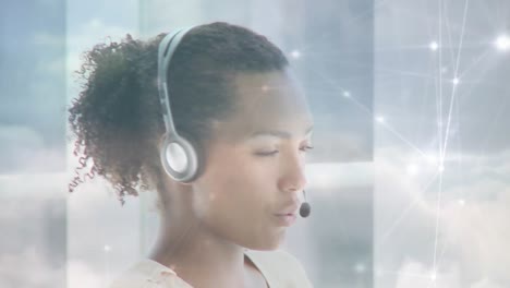 Animation-of-networks-of-connections-over-businesswoman-using-phone-headsets-over-sky