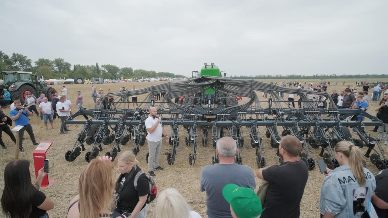 демонстрация сельскохозяйственной техники на выставке. тракторы работают в поле, демонстрируя свои возможности и производительность в действии