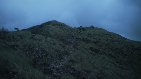 The-top-of-a-hill-with-dark-clouds-in-the-background